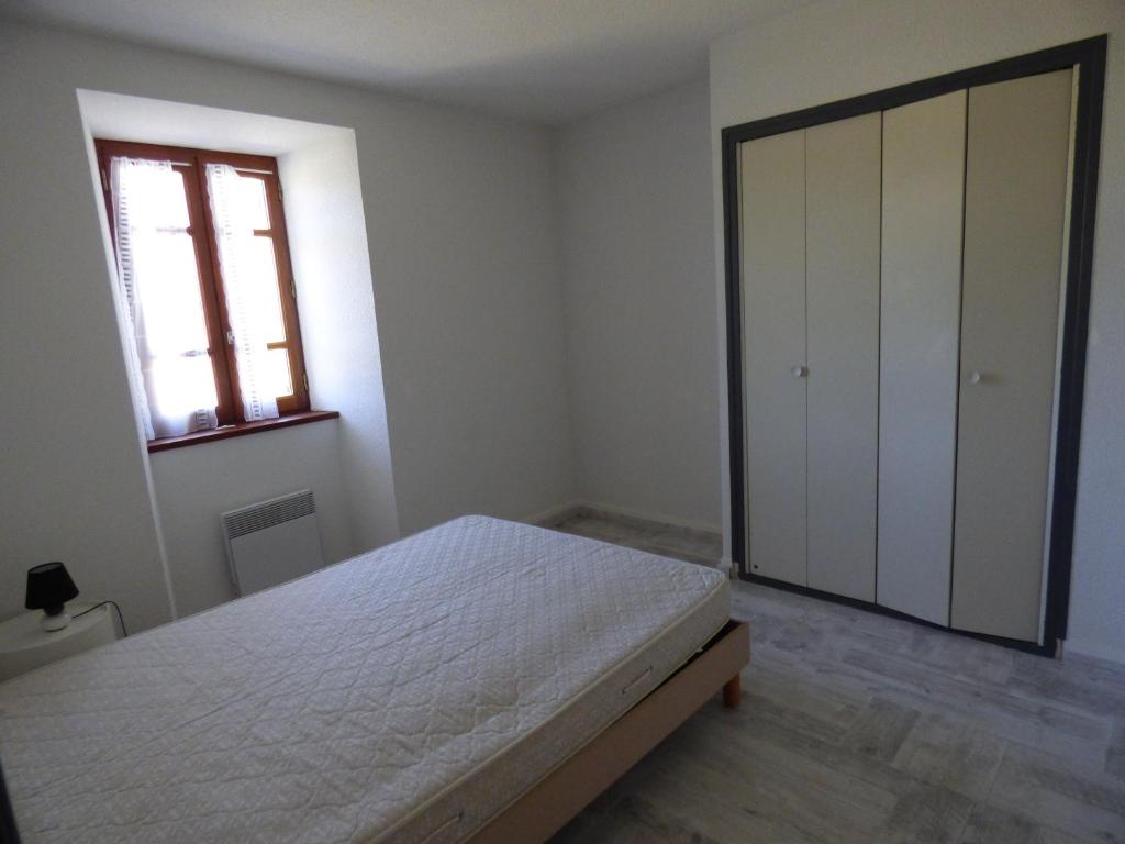 a bedroom with a bed and a window and a door at Auberge Les Grillons in Meyras