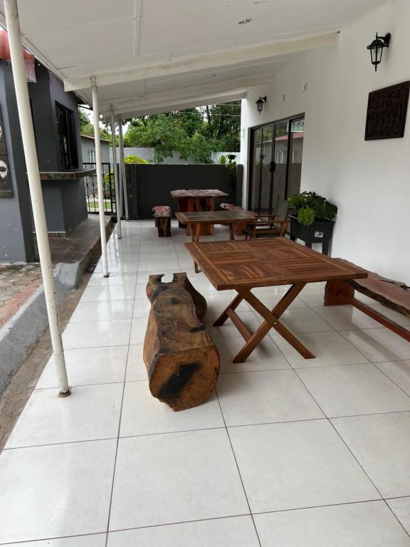 a wooden table and benches on a patio at Mukala Lodge in Lusaka