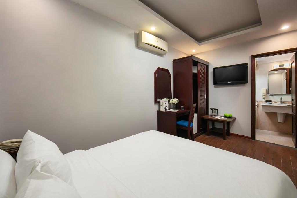ein Hotelzimmer mit einem weißen Bett und einem Bad in der Unterkunft Cristina Center Hotel & Spa in Hanoi