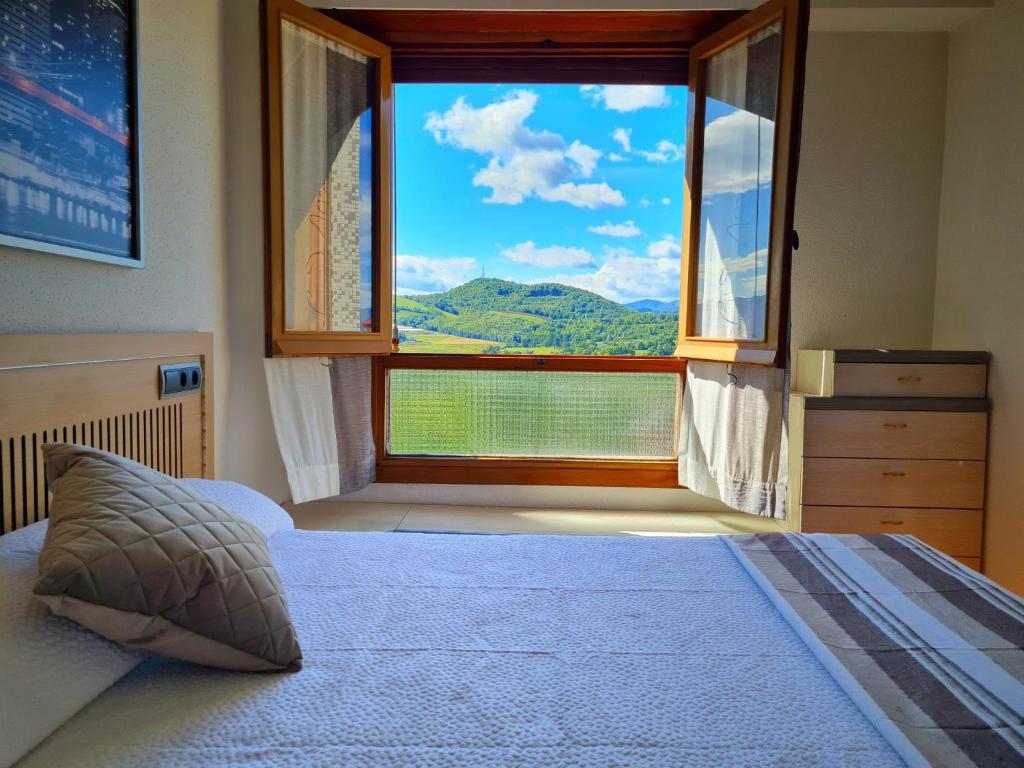 a bedroom with a large window with a mountain view at Apartamento San Marcos by SanSe Holidays in San Sebastián