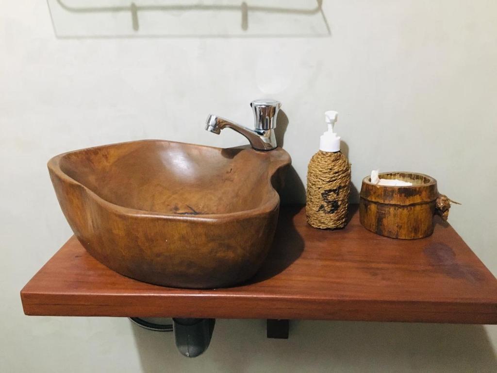 a copper sink sitting on a wooden shelf at Sky View Cabin Unawatuna in Unawatuna