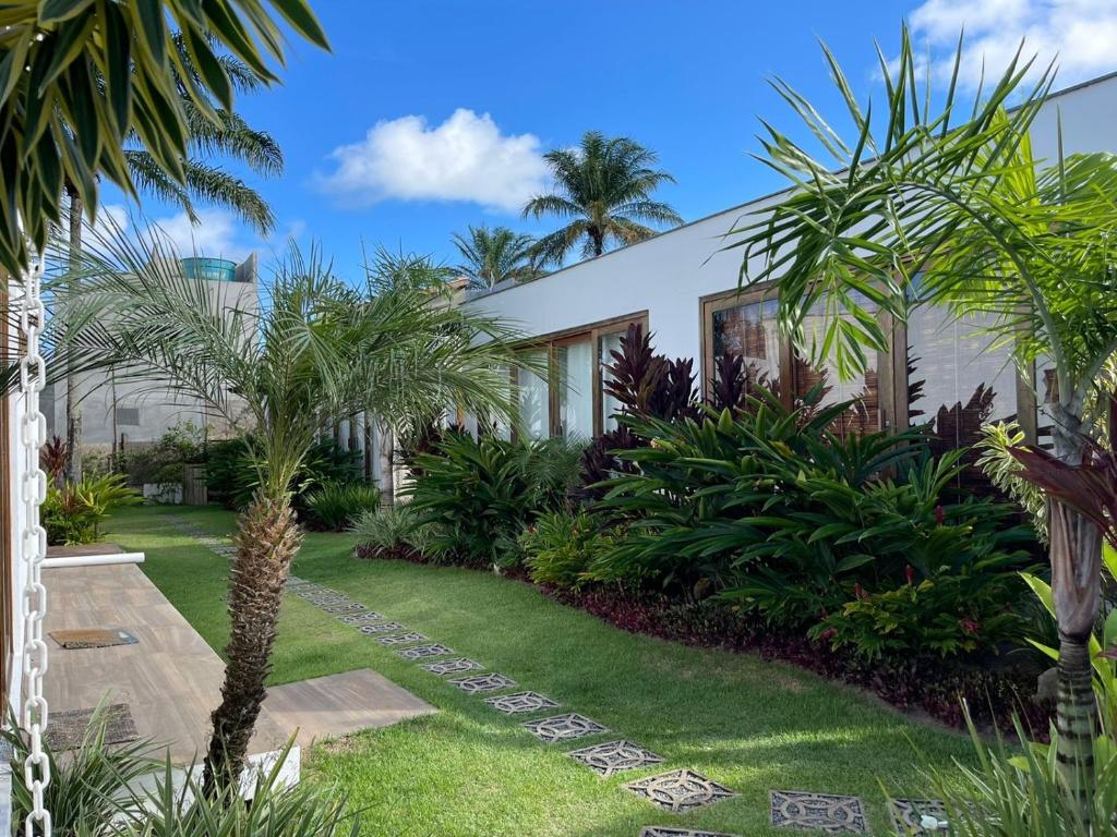 a building with palm trees in front of it at Casa em condomínio na Barra Grande 350m da praia da Ponta do Mutá in Marau