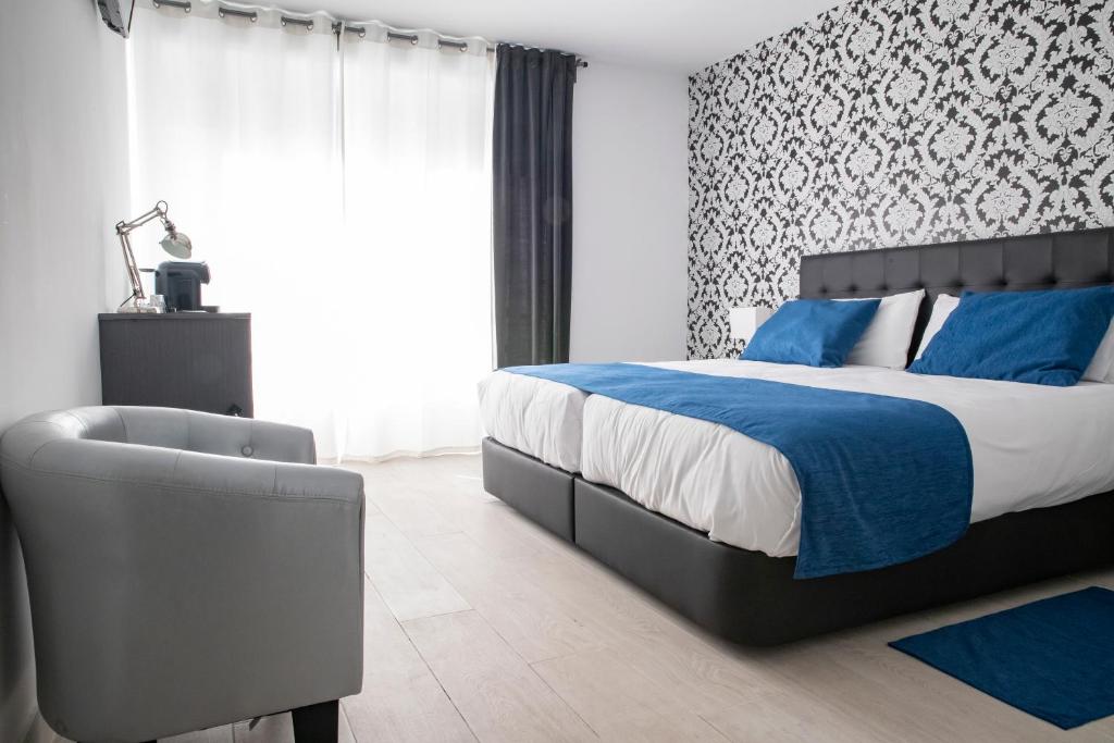 1 dormitorio con 1 cama y 1 silla en Hostal Boutique I Host You, en Madrid
