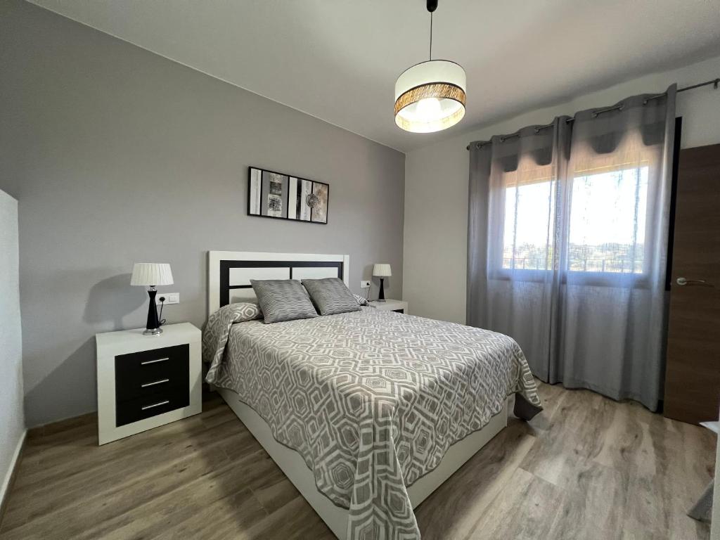 a white bedroom with a bed and a window at Casa Rural "El Cañuelo" in Aljucén