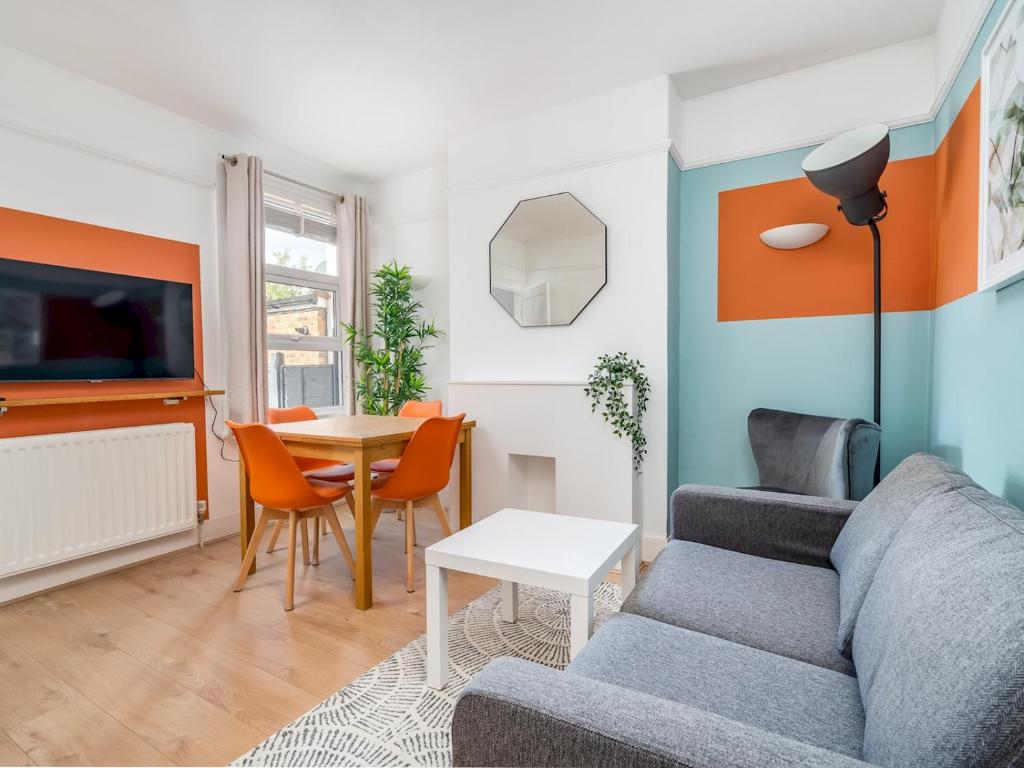 un salon avec un canapé et une table dans l'établissement "FurnishedRentals Direct" WiggenHouse Stylish 3 Bedroom house Sleeps 8 with Free Parking, 2 Bathrooms, near to Watford High Street and Watford Football Stadium, Suitable for visiting Harry Potter Warner Bros Studio and London, à Watford