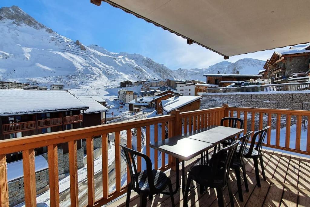 a table and chairs on a balcony with snow covered mountains at Tignes2100 - Le Télémark in Tignes
