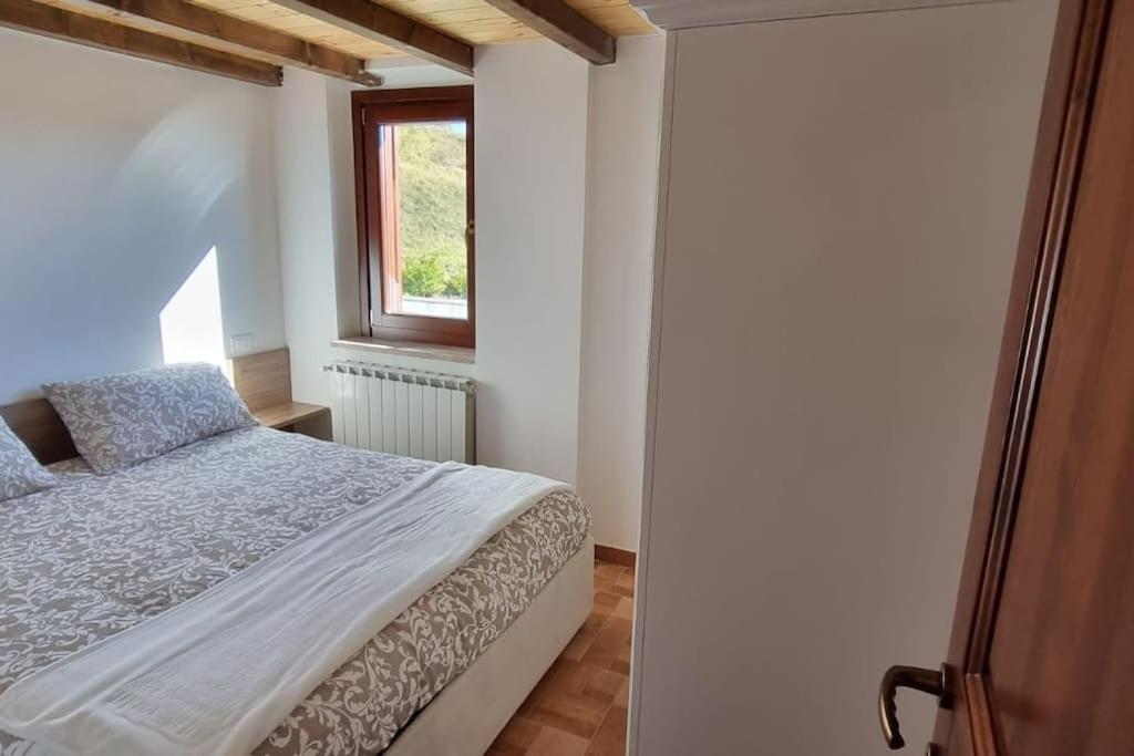 Schlafzimmer mit einem Bett und einem Fenster in der Unterkunft Il nido in Castel di Sangro
