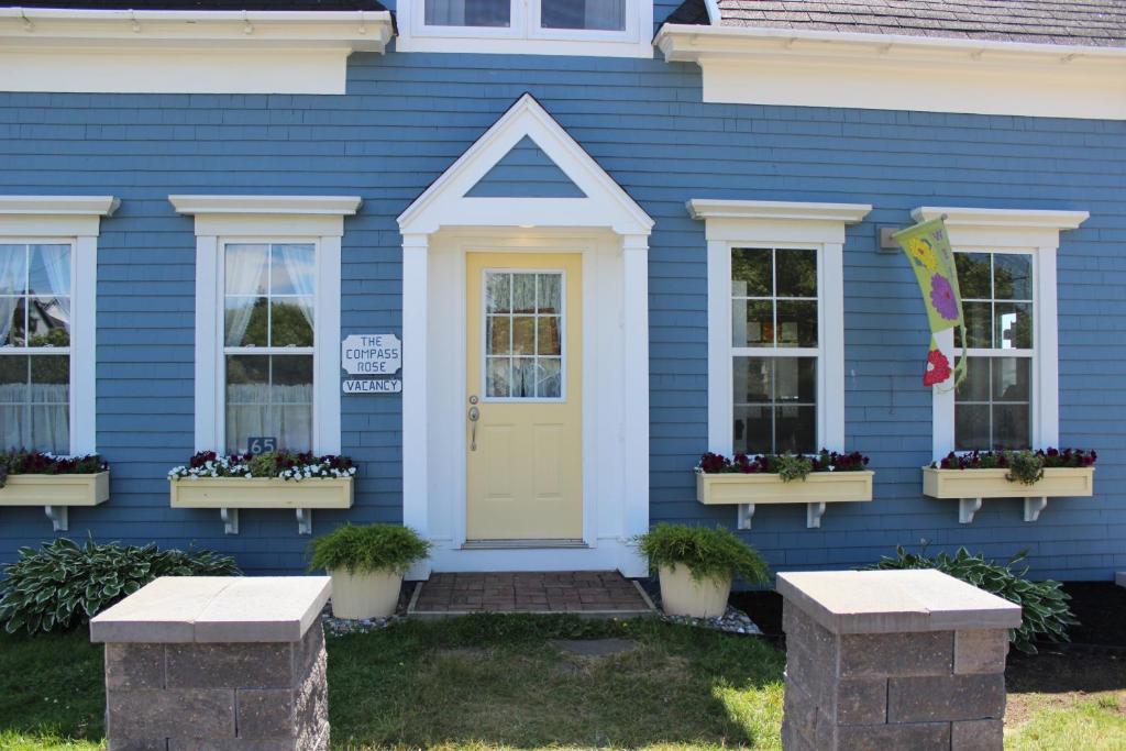 a blue house with a yellow door and windows at Compass Rose Heritage Inn in North Head