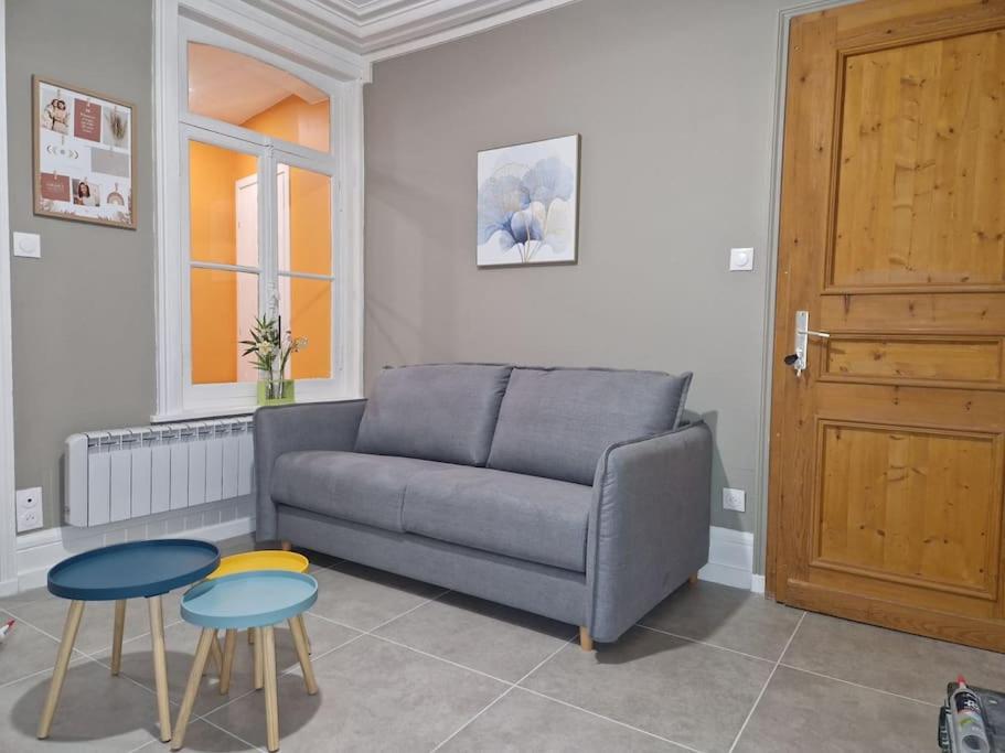 een woonkamer met een bank en 2 tafels bij Bel Appart - Rez-de-chaussée - Hyper centre in Saint-Omer