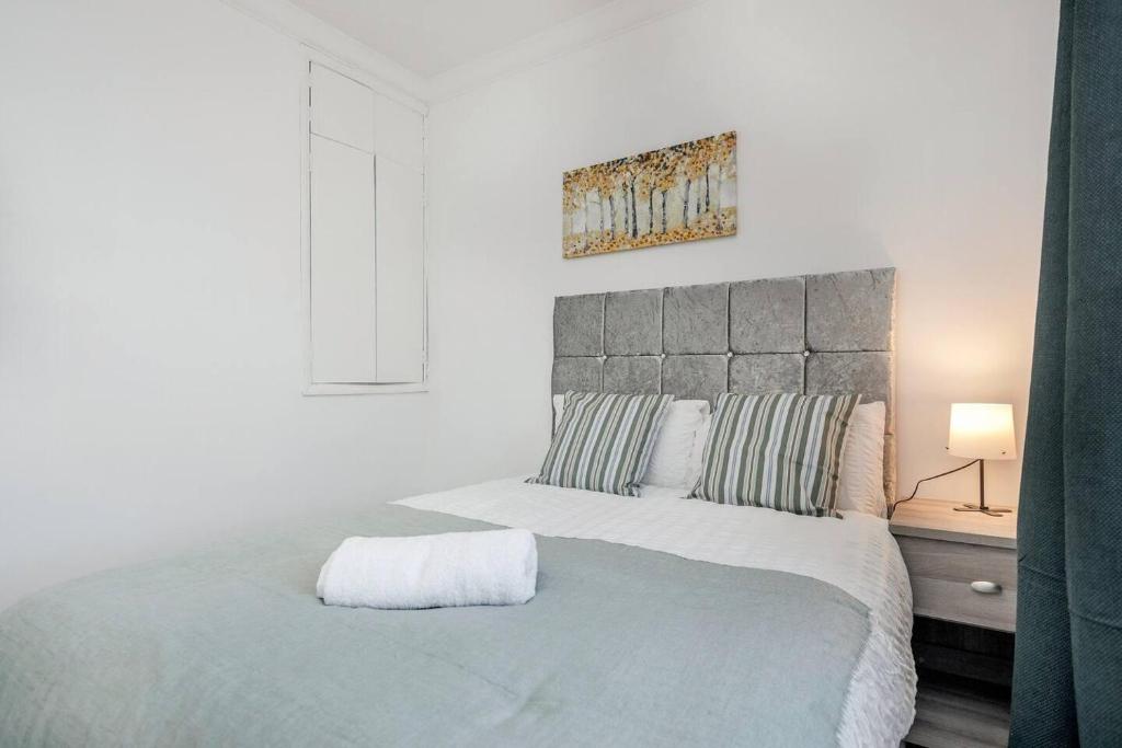 una camera da letto con un letto bianco e un cuscino bianco di Stunning Top 2 Bed Flat Tilbury Central Location a Tilbury