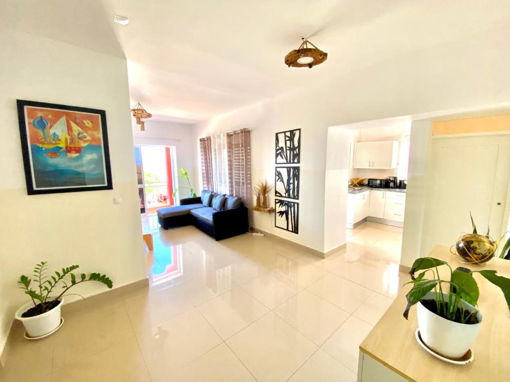 Tarrafal Odyssea في تارافال: غرفة معيشة كبيرة مع أريكة زرقاء والنباتات
