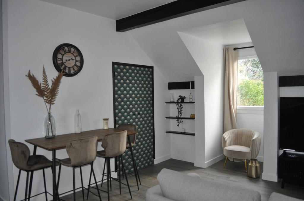 a living room with a table and chairs and a clock at Charmant T3 au cœur de Agen Sud in Agen