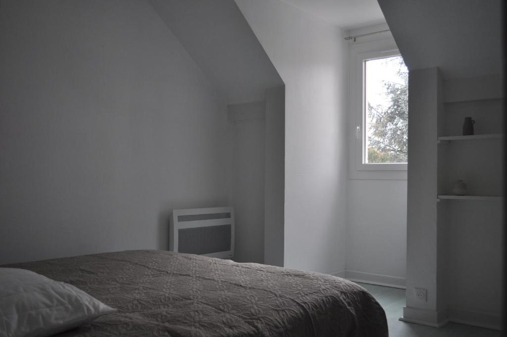 a white bedroom with a bed and a window at Charmant T3 au cœur de Agen Sud in Agen