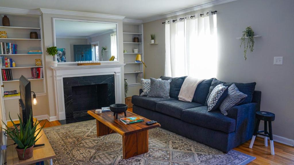 a living room with a blue couch and a fireplace at Franklin Park condo 5 mins from airport, Walk to Conservatory in Columbus