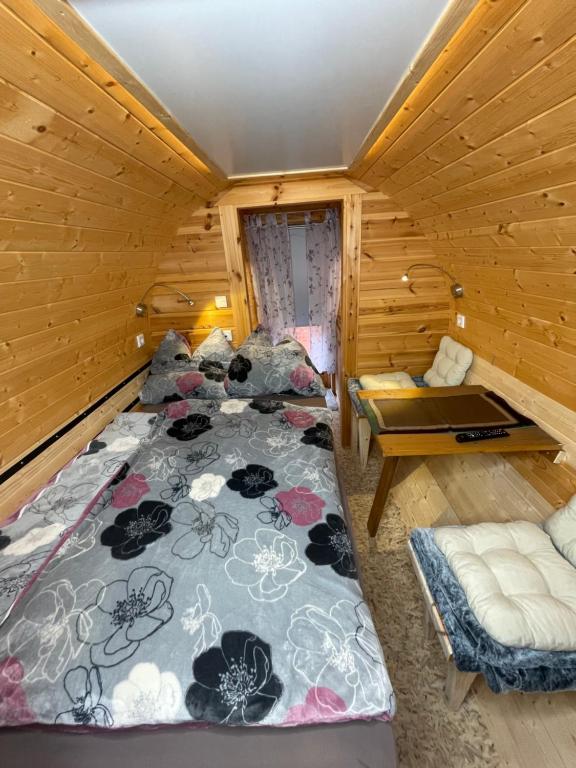 a bedroom with two beds in a wooden cabin at Haus Geyken / Finnen Fass in Südbrookmerland