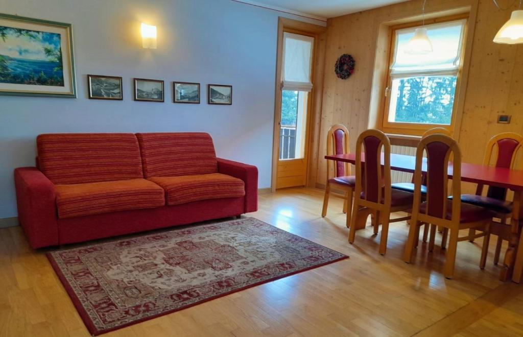 a living room with a red couch and a table at Casa Felice in Valfurva