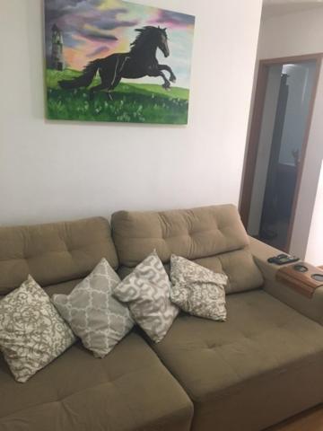 a living room with a brown couch with pillows at APT A 10 MIN DA CIDADE DE PENEDO in Resende