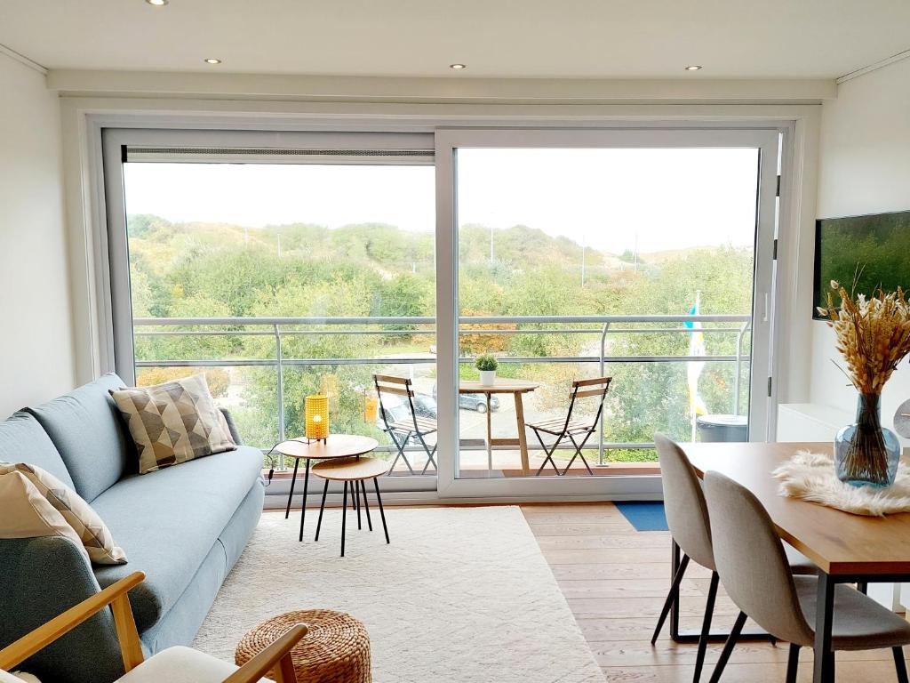 un soggiorno con divano e una grande finestra di Studio 3 Bredene met strandcabine a Bredene