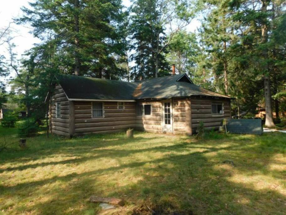 a log cabin in the middle of a field at O Me, O Mio Cabin near the AuSable River in Mio