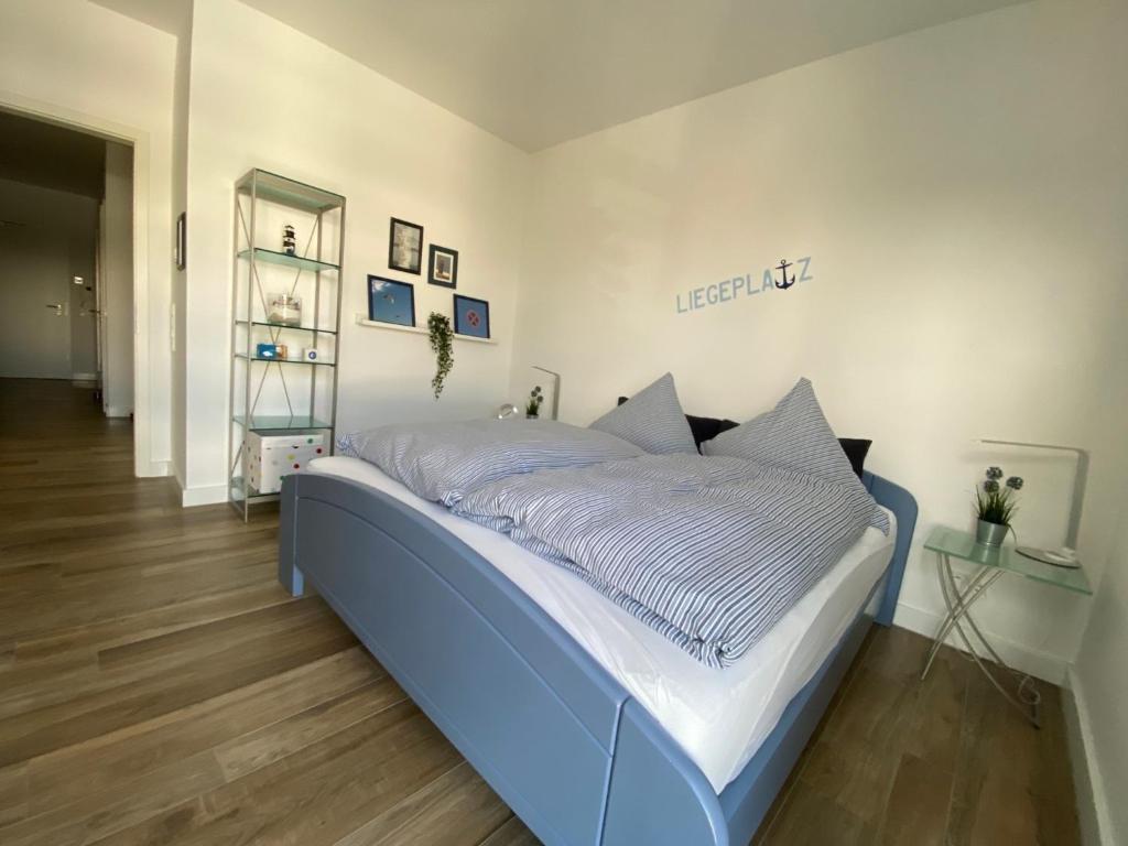 uma grande cama azul num quarto com pisos em madeira em Port Marina "Schlagseite" em Bremerhaven