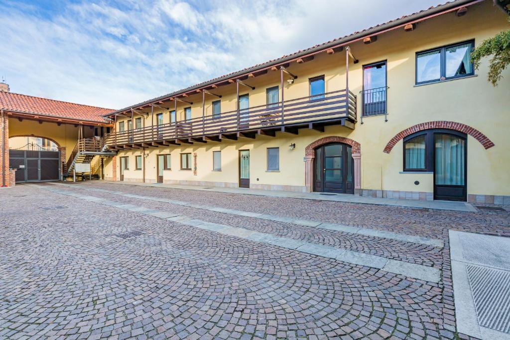 a building with a cobblestone street in front of it at Cascina 6b in San Maurizio Canavese