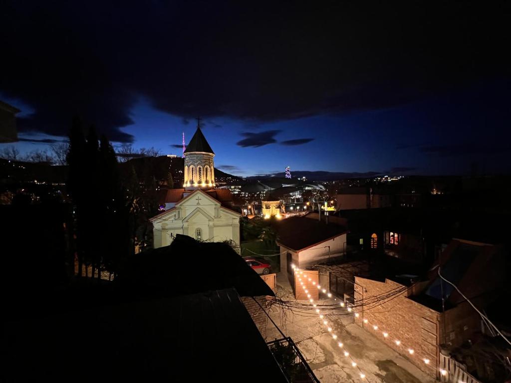 une église avec une tour éclairée la nuit dans l'établissement Hotel Old Tbilisi 5 rooms, à Tbilissi