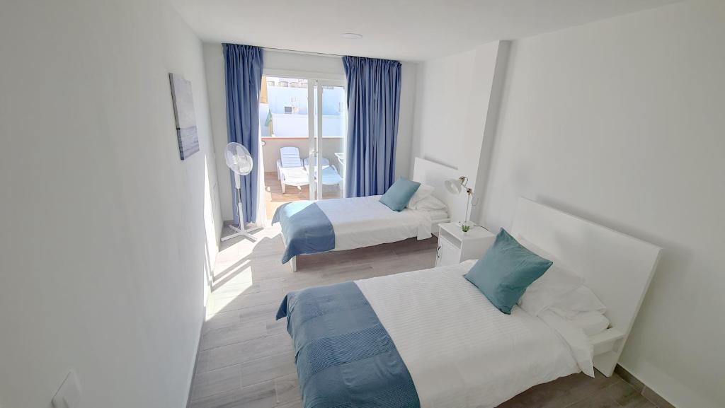 Łóżko lub łóżka w pokoju w obiekcie La Hoya 29 Apartments