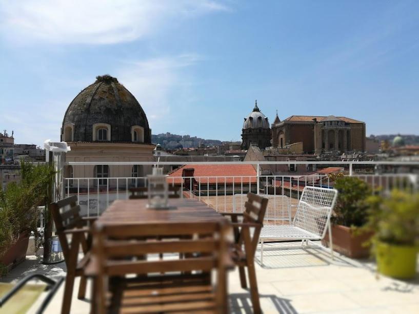 einen Tisch und Stühle auf dem Dach eines Gebäudes in der Unterkunft Naples in the history 4M in Neapel