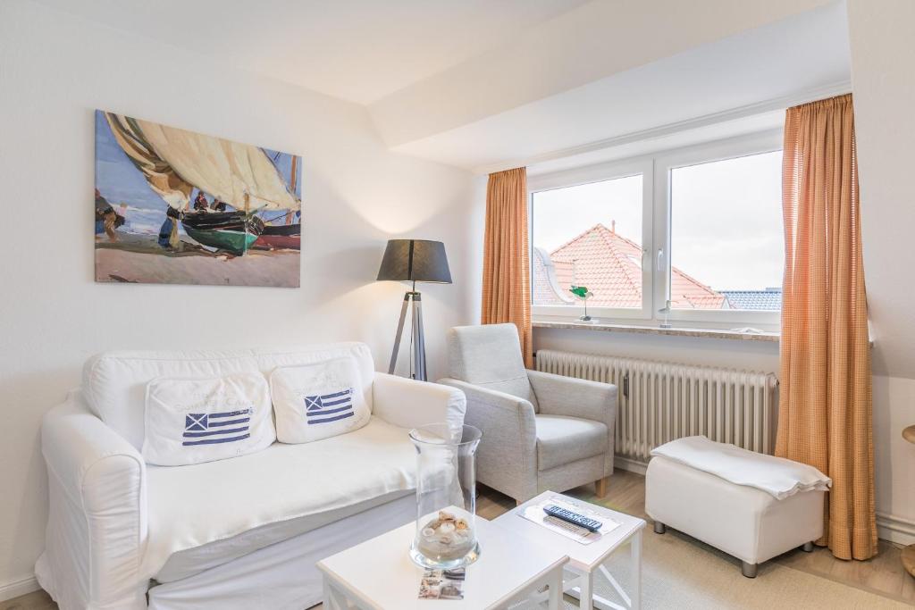 uma sala de estar com um sofá branco e uma cadeira em Haus Alleestraße 37 Haus Alleestraße 37, Wohnung 3 em Büsum