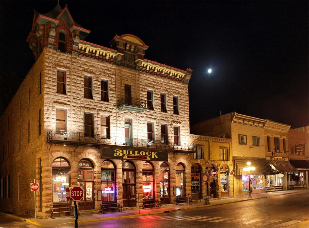 ein Gebäude an der Ecke einer Straße nachts in der Unterkunft Historic Bullock Hotel in Deadwood