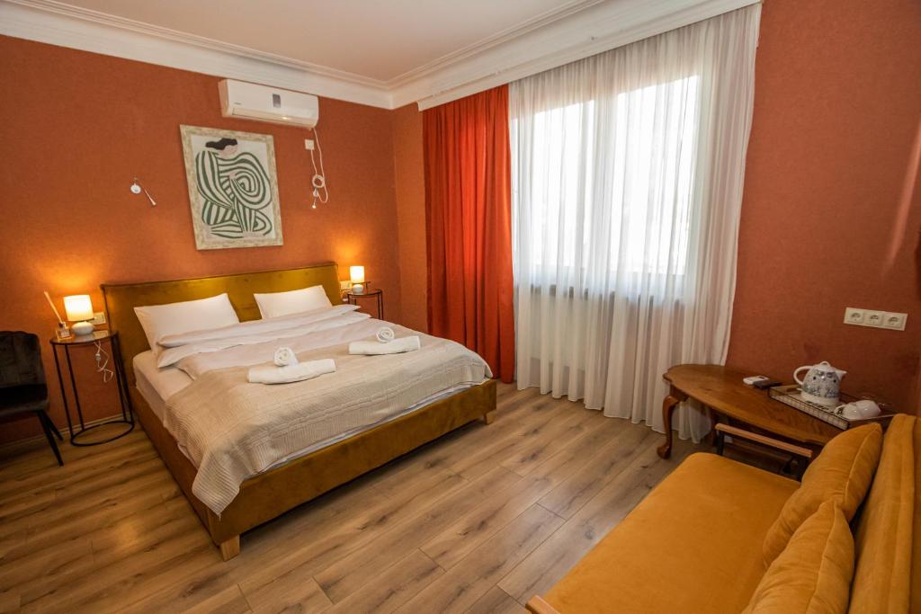 a bedroom with a bed and a desk and a window at Hotel Old Tbilisi 5 rooms in Tbilisi City