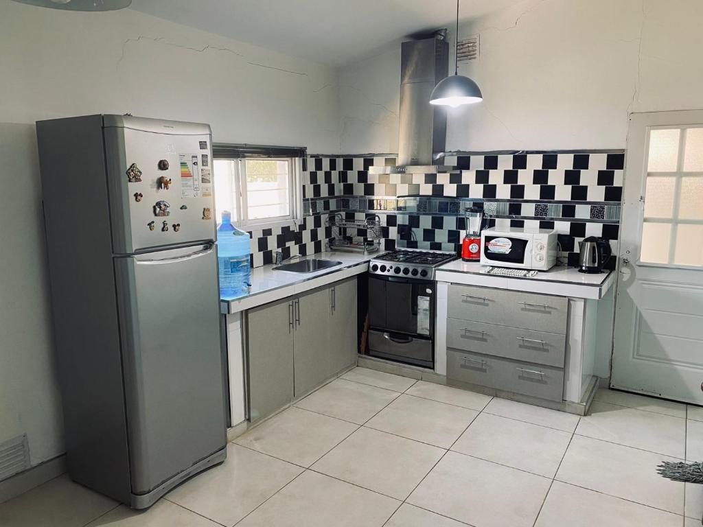 a kitchen with a refrigerator and a stove at Casa Daval solo Familias in Villa Carlos Paz