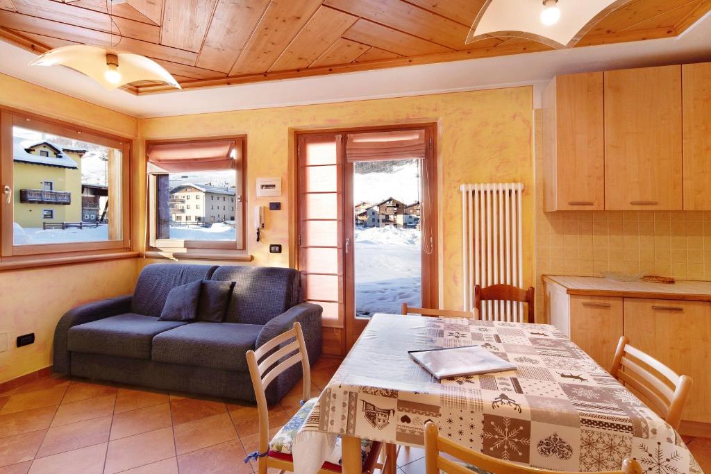 ein Wohnzimmer mit einem Tisch und einem Sofa in der Unterkunft Red Casa Maurizio in Livigno