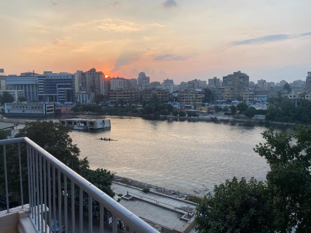 - une vue sur une rivière dans une ville au coucher du soleil dans l'établissement Nile View 2-Bed Apartment in Zamalek Cairo, au Caire