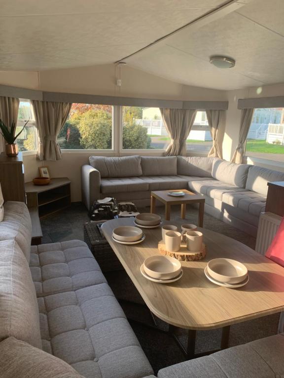 a living room with a couch and a table at ParkDean Cherry tree holiday park Burgh castle in Belton