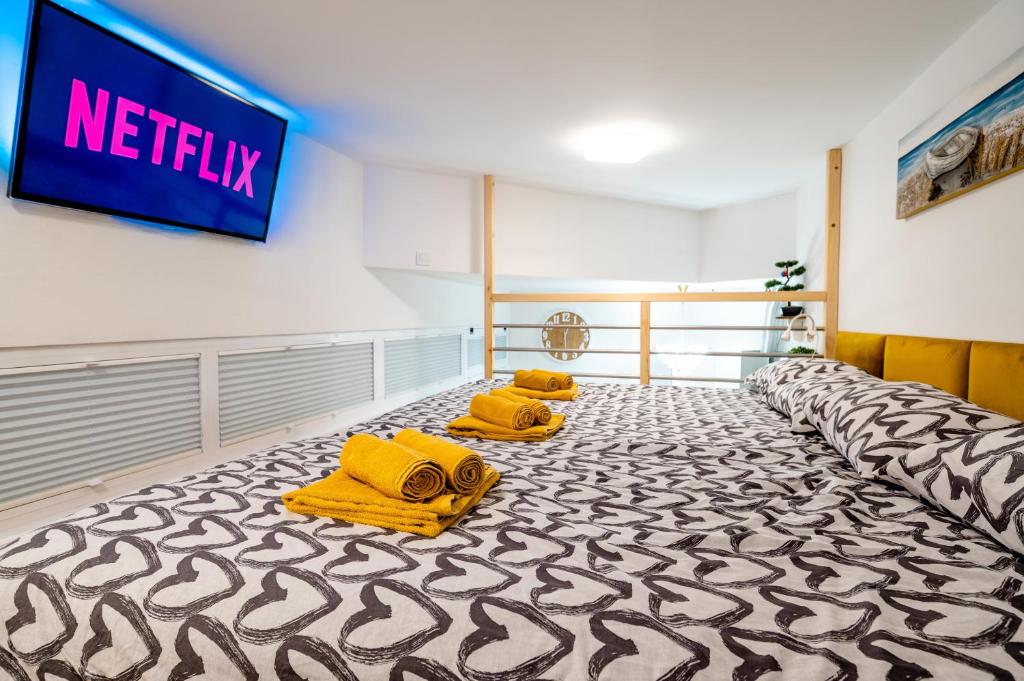 een hotelkamer met 2 gele bedden en een televisie bij Studio Apartment LION Portorose in Portorož