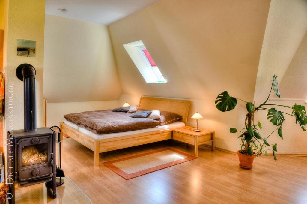 - une chambre avec un lit et un poêle à bois dans l'établissement "Haus Landblick" Haus Landblick Whg Turmzimmer, à Büsumer Deichhausen