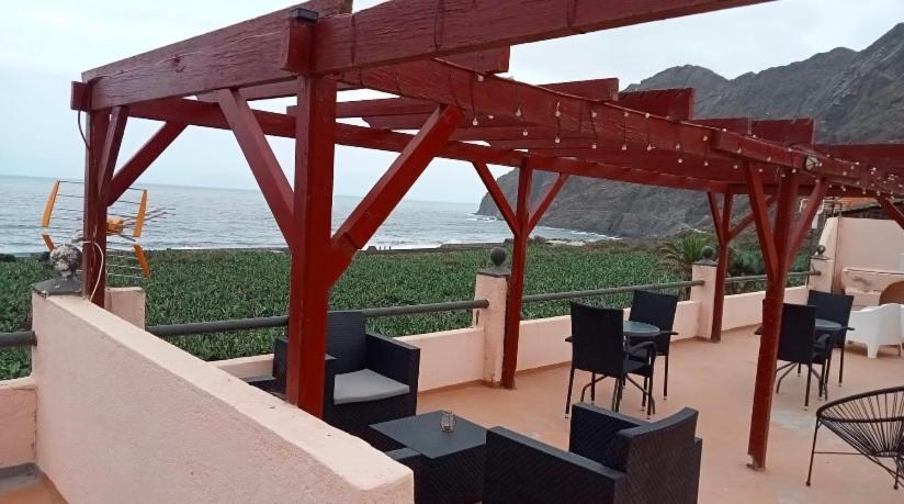 a pavilion with chairs and tables and a view of the ocean at ApartamentosPlaya_Hermigua in Hermigua