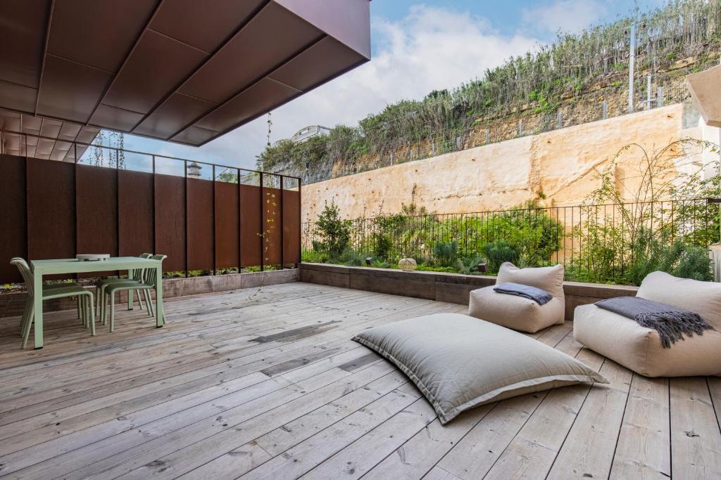 a patio with a table and chairs on a wooden deck at Deluxe 2BDR Apartment W/ Patio by LovelyStay in Lisbon