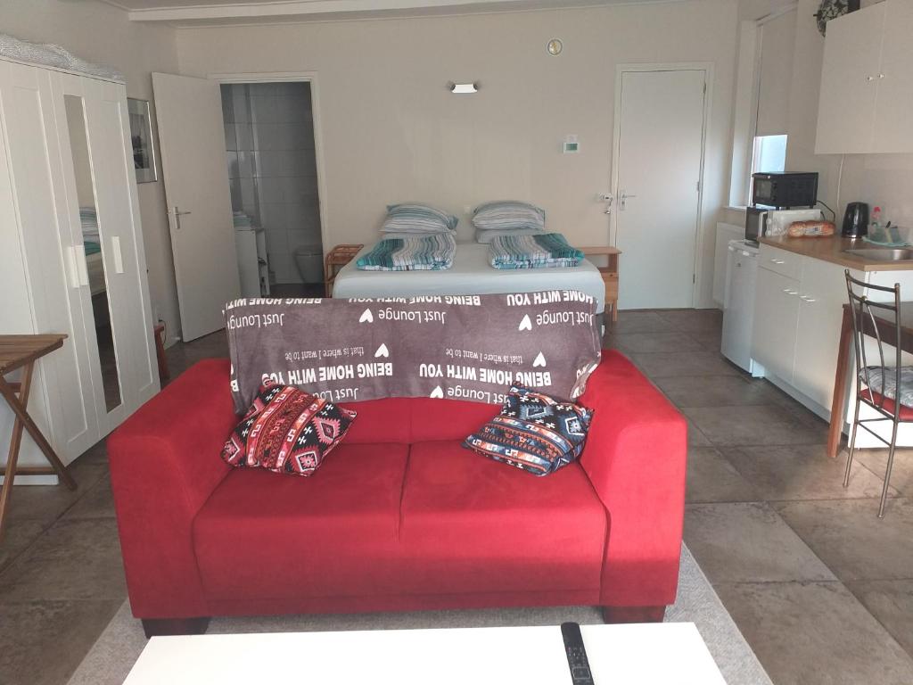 een rode bank met een bed erop bij Thorbecke Canal View 42 m2 Loft in Zwolle