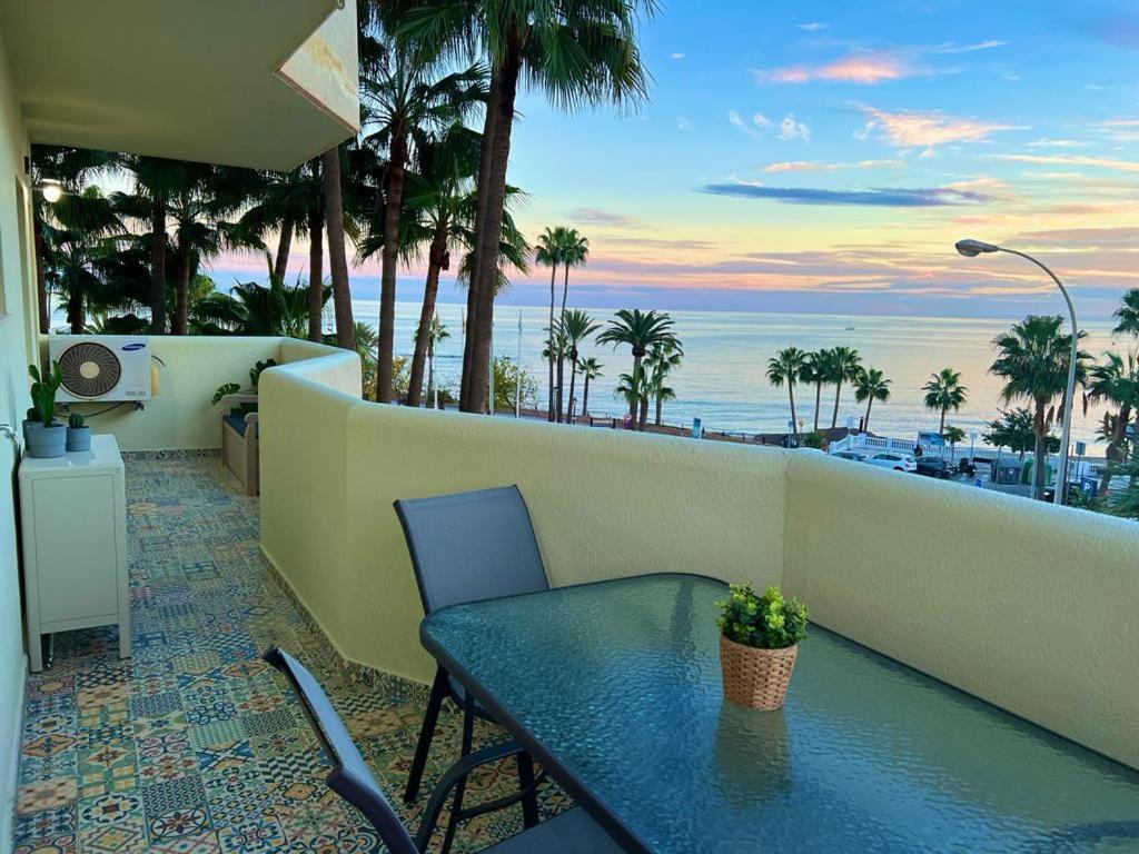 uma mesa e cadeiras numa varanda com vista para o oceano em Apartamento con vistas al mar em Benalmádena