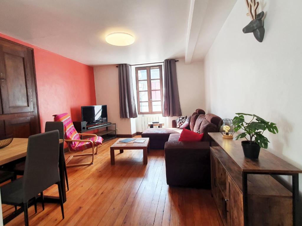 ein Wohnzimmer mit einem Sofa und einem Tisch in der Unterkunft La ruelle des 2 vallées in Arreau