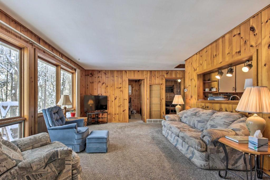 uma sala de estar com um sofá e cadeiras e uma televisão em Serene Woodruff Cottage Lakefront Access! em Woodruff
