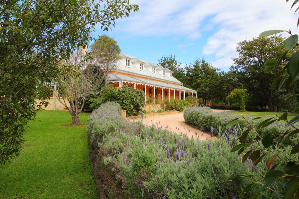 a large house with a large garden in front of it at Fitzroy Inn Historic Retreat Mittagong in Mittagong