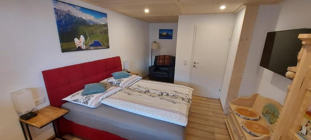 a small bedroom with a red bed in a room at Haus Wibmer Martin in Matrei in Osttirol