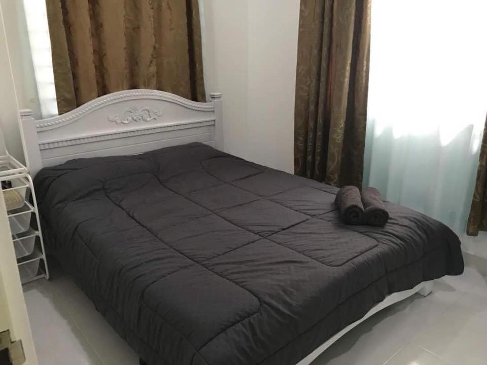 a bedroom with a large bed with a black comforter at Inap Singgah Homestay in Kota Bharu