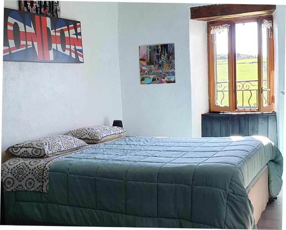 a bedroom with a bed and a window at Horizon Aubrac Laguiole in Laguiole