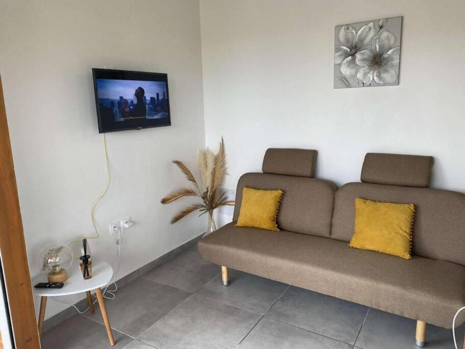 un soggiorno con divano e TV a parete di T2 Climatisé avec wifi à Sainte-Anne en campagne a Sainte-Anne