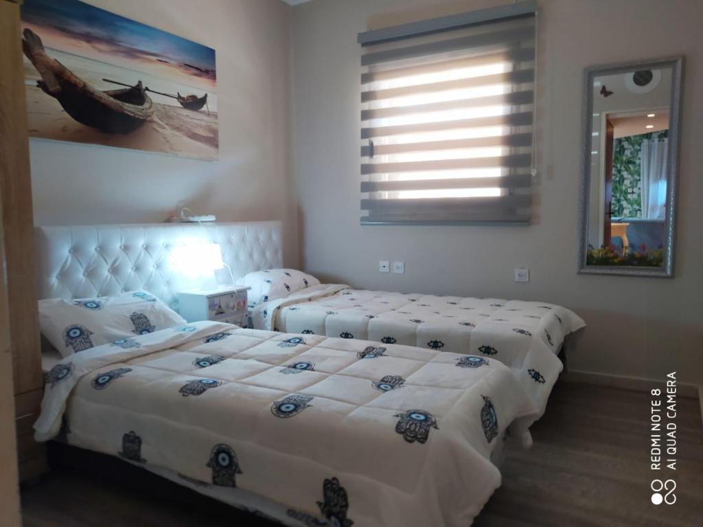 1 dormitorio con 2 camas y ventana en Apartment Amdar Village with garden en Eilat