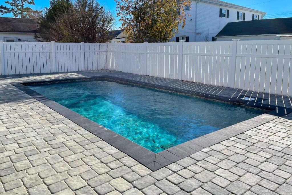 een zwembad in een achtertuin met een wit hek bij New-Build North Wildwood Home with Private Pool in North Wildwood